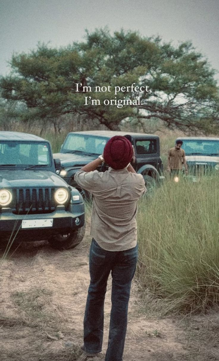 a man is standing in the dirt with his hands on his head and looking at jeeps