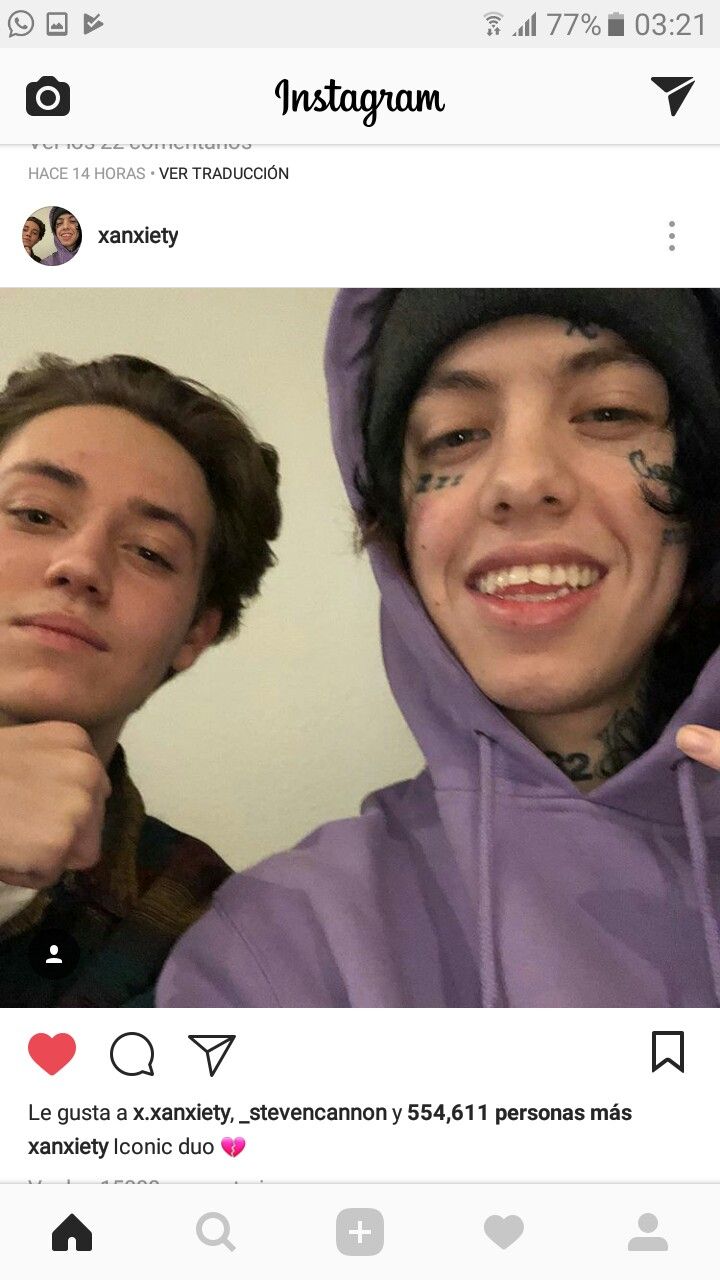 two people wearing hoodies and one is pointing at the camera with an instagram