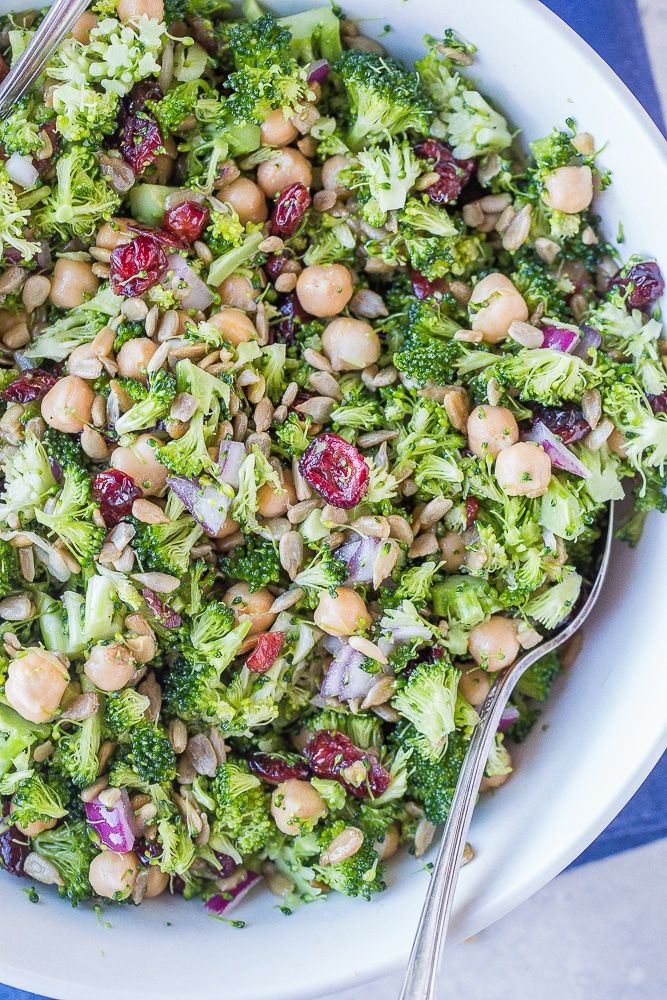 a bowl filled with broccoli and beans on top of a blue table cloth