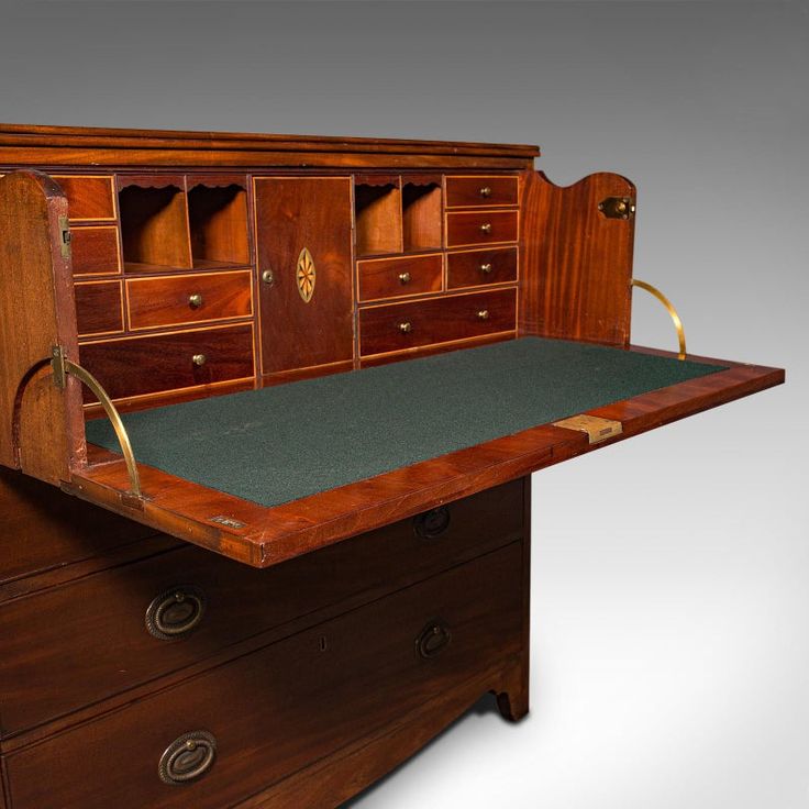 an old wooden desk with green felt on the top and bottom drawer, in front of a white background