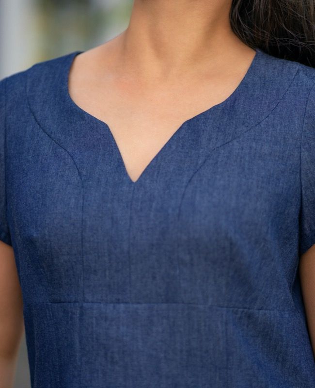 a close up of a woman wearing a blue dress