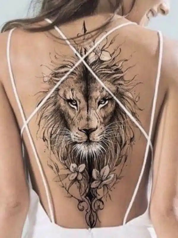 the back of a woman's body with a lion tattoo on her shoulder and chest