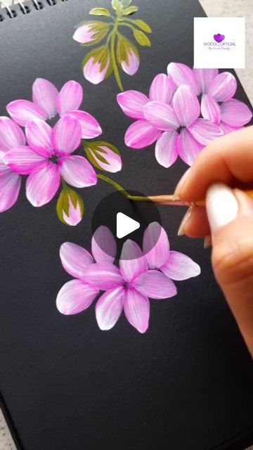 someone is drawing flowers on a black paper