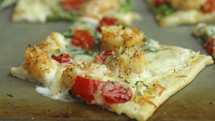 a pizza that is sitting on top of a pan covered in cheese and veggies