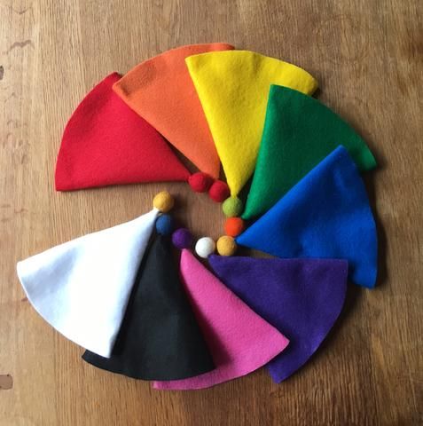 several different colored hats on a wooden table