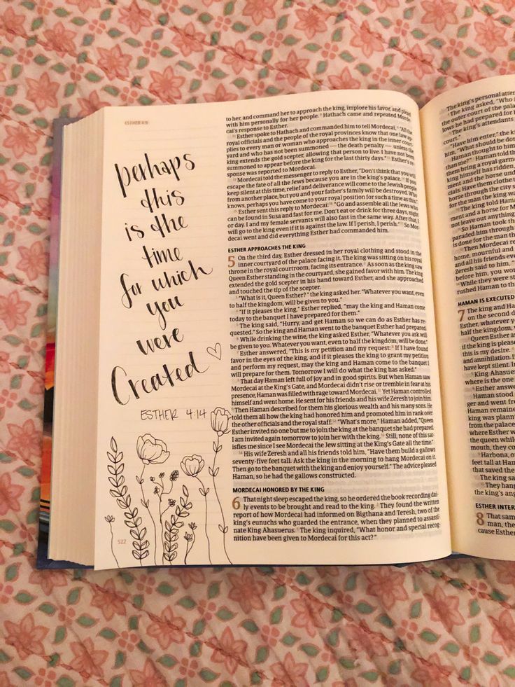 an open book with handwritten text on it sitting on a floral print tablecloth