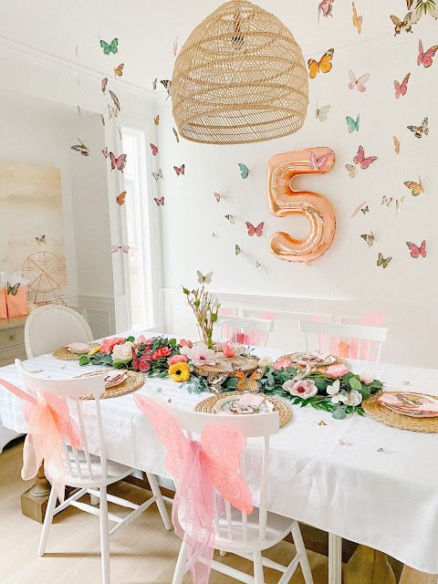 the table is set with flowers and plates for an elegant birthday party or special celebration