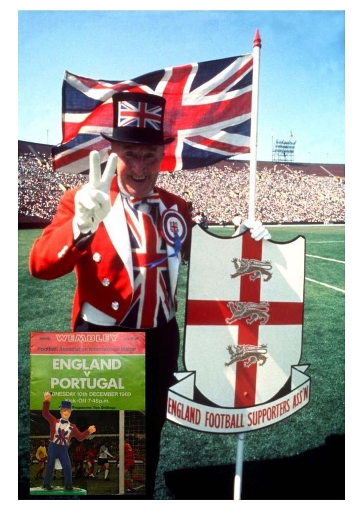 a man in a red and white uniform holding a flag on top of a field