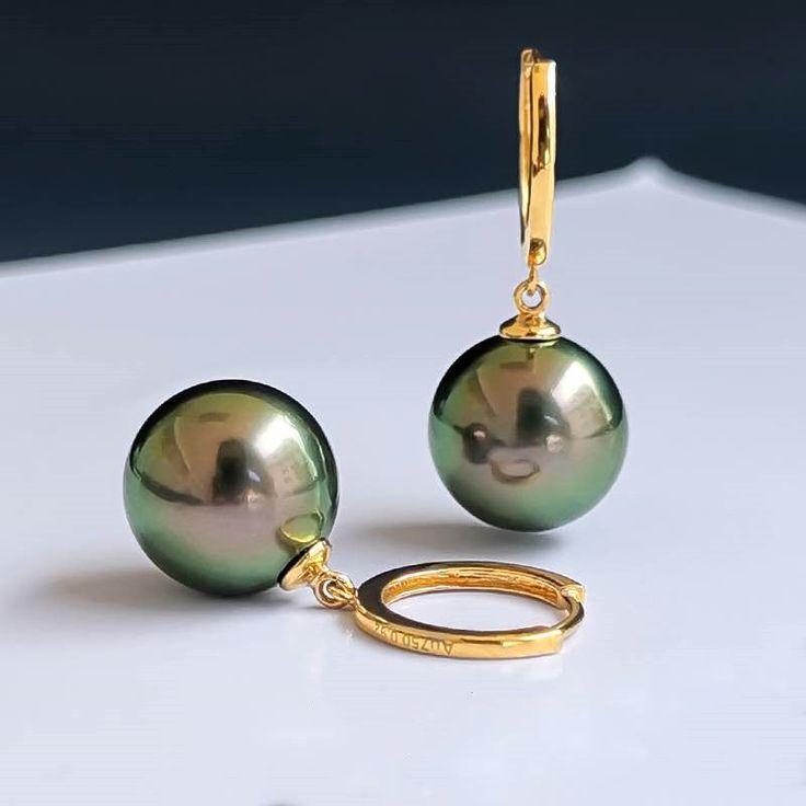 Tahitian drop earrings stunning appearance for fashion style Tahitian pearl earrings exude elegance and sophistication. Featuring peacock malachite green accents and 18K gold-plated hoops, and 18K gold-plated hoops, they emit a classic and timeless charm. The pearl has a mirror-like luster, making them a perfect match for a simple dress or pantsuit, as well as casual denim or t-shirt, adding a touch of luxury to any outfit. Real pearl earrings with 18K plated clasp The earrings are made of high- Green Pearl Earrings, Real Pearl Earrings, Tahitian Pearl Earrings, Malachite Green, Green Pearls, Simple Dress, Freshwater Pearls Earrings, Real Pearls, Pearl Types