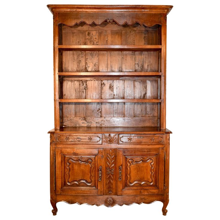 an old wooden bookcase with carvings on the top and bottom shelf, against a white background