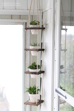 a hanging planter with plants in it on the side of a window sill