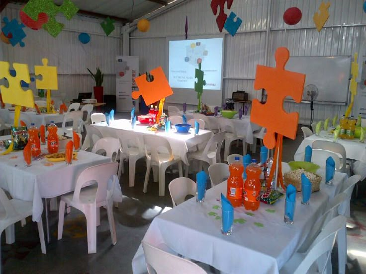 a room filled with tables and chairs covered in white tablecloths topped with orange crosses