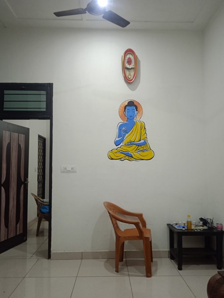 there is a room with a chair and a buddha painting on the wall above it