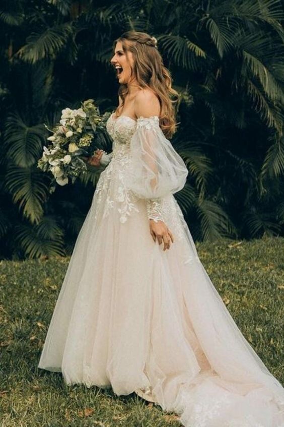 a woman in a wedding dress standing on the grass