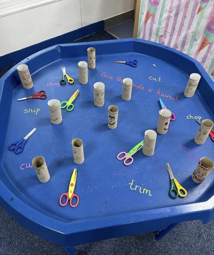 a blue tray with cups and scissors on it