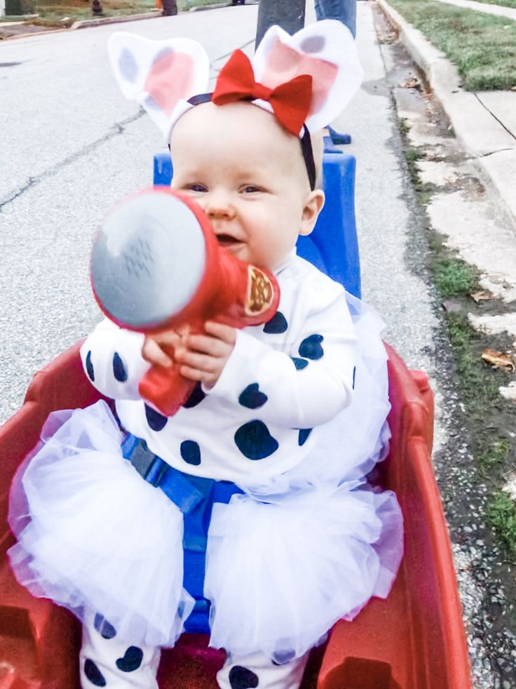 a baby sitting in a wagon with a blow dryer on it's head