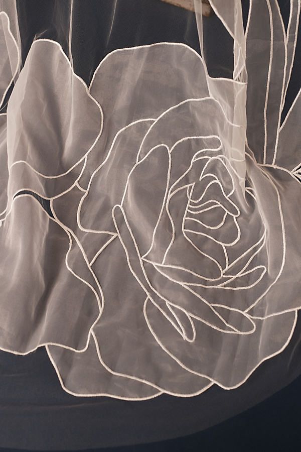 an image of a white rose on the sheer fabric that has been embroidered onto it