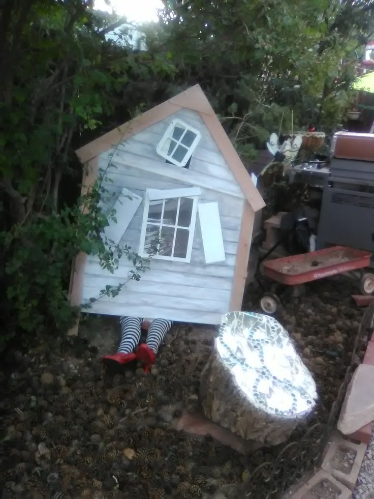 a doll house sitting on top of a pile of dirt next to a fire hydrant