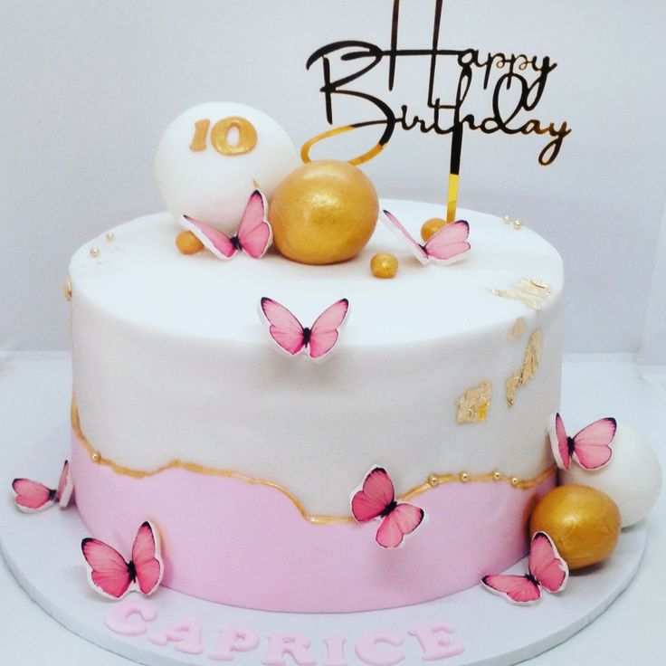 a birthday cake decorated with pink and gold butterflies