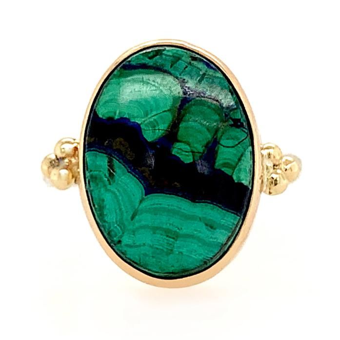 A bold green Azurite Malachite cab is set in 14k yellow gold with gold accent bead and a freeform sterling silver band. Approximate stone size: 18mm x 14mm This piece is handmade with love in our Hudson Valley studio. In order to highlight each stone's color and vibrance most of our gemstone jewelry is backed in nickel free sterling silver. Please allow for slight variations in stone size, color and shape. Allow 14-21 business days to ship. 14k Gold Green Cabochon Jewelry, Oval Green Gemstones In 14k Gold, Oval Malachite Jewelry In Yellow Gold, Formal Oval Malachite Jewelry, Oval Malachite Emerald Ring, Green Oval Malachite Jewelry, Oval Green Malachite Jewelry, Oval Malachite Gemstone Jewelry, Green Oval Jewelry With Large Stone