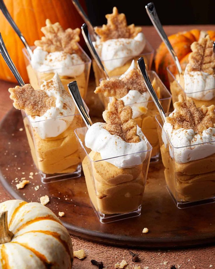 small desserts are arranged on a plate with pumpkins and other decorations in the background