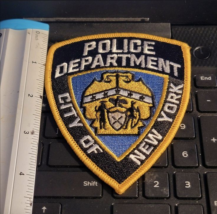 a police department patch sitting on top of a laptop computer