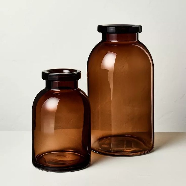 two brown glass jars sitting next to each other