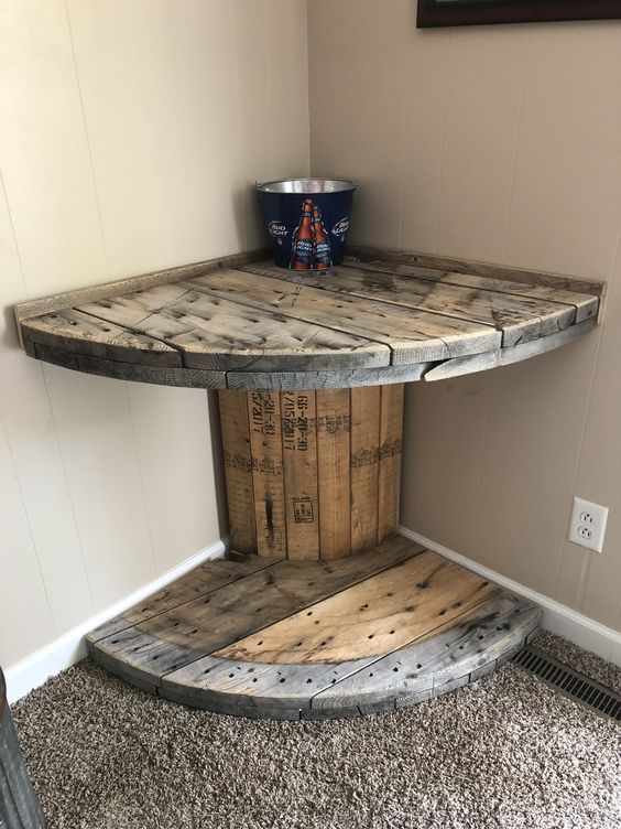 a table made out of wooden pallets in a corner with a bucket on top