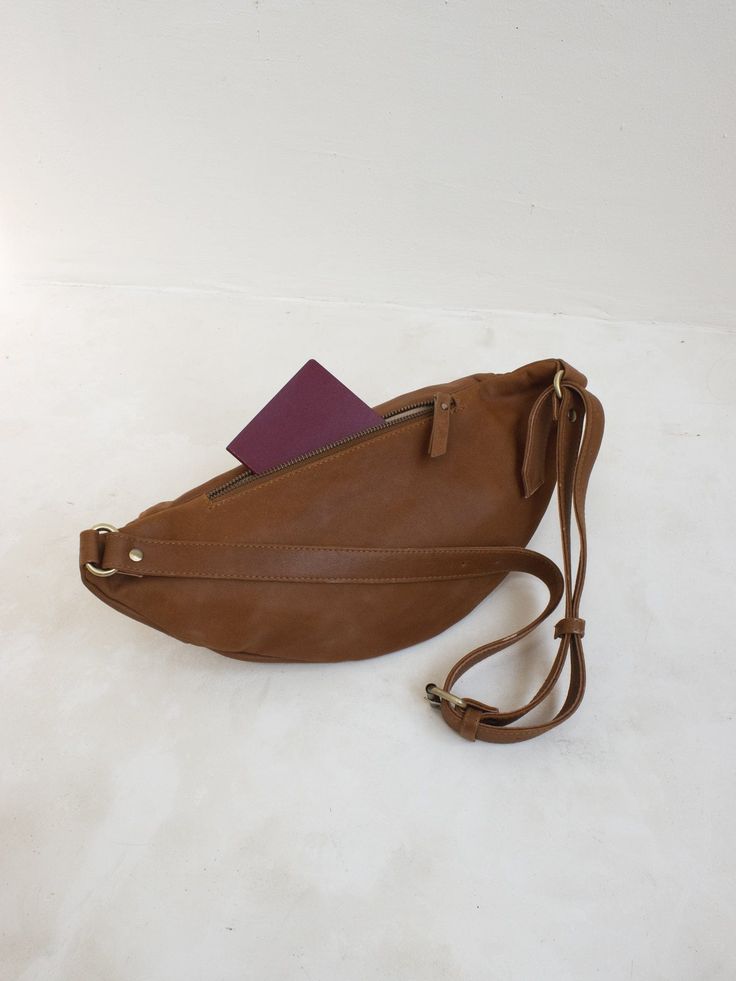 Meet the Atlas in Tan – now with more secret pockets and features to make staying organized on the go that much easier. Chase your next adventure and let this timeless leather fanny pack design carry you from plane ride to sunset and everywhere in between. Handmade by artisans in Bali, this roomy design is both elegant and versatile. For endless styling freedom, easily adjust the leather strap to wear as a bum bag, cross-body or over-the-shoulder. Travel Perfume, Plane Ride, Hip Pack, Pack Design, Gift Inspo, Bag Belt, Waist Pouch, Leather Fanny Pack, Leather Conditioner