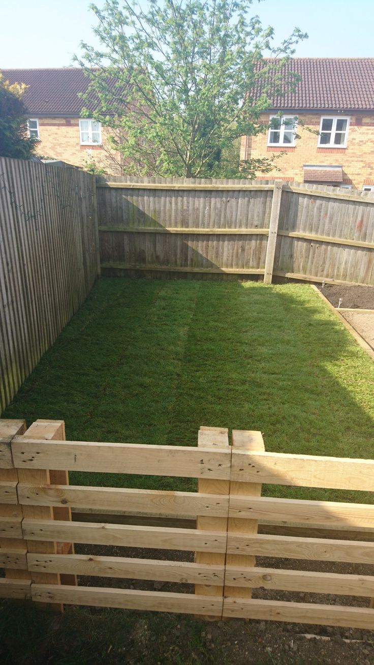 a wooden fence in the middle of a yard