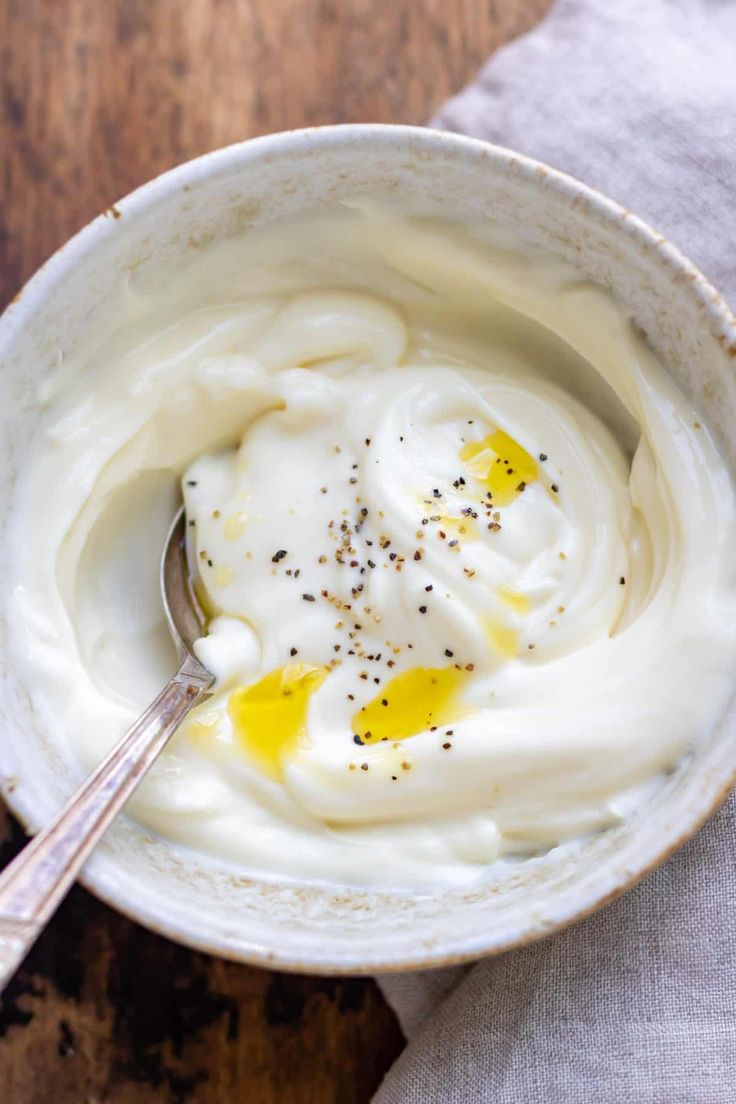 a white bowl filled with cream and an orange on top