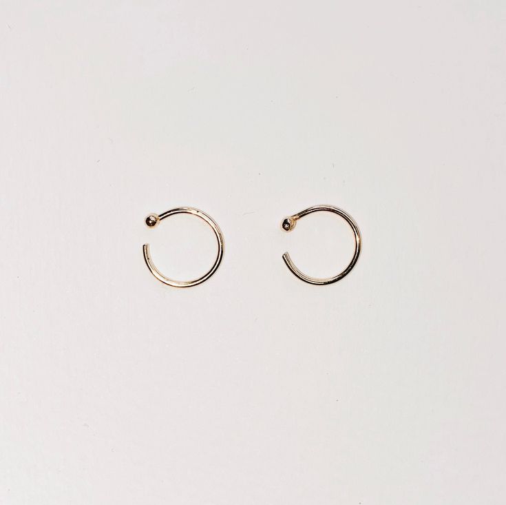 GOLD HUGGIE GOLD HUGGIE earrings made in Solid 14k Yellow Gold. Dainty open hoops with 1.5mm balls. A cuff earring that hugs your ears. Shiny Yellow Gold hoops that you can wear everyday, literally. An everyday staple and heirloom. Perfect for your earlobes, cartilage or tragus. Style with your favorite earrings. An easy classic. + 14ky Gold huggie hoops + Sold as 1 single or pair + 1.5mm ball + 10mm diameter + Please allow 3-5 business days to ship out. Minimalist 14k Gold Filled Piercings, Everyday Minimalist 14k Gold Ear Cuff, Minimalist Rose Gold Huggie Cartilage Earrings, Minimalist 14k Gold Huggie Rings, Minimalist Rose Gold Small Hoop Piercings, Minimalist Small Hoop Ear Cuff, Tarnish Resistant, Minimalist Small Hoop Ear Cuff Tarnish Resistant, Tiny Minimalist 14k Gold Filled Cartilage Earrings, Minimalist 14k Gold Huggie Ear Cuff