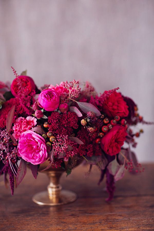 a vase filled with pink flowers on top of a wooden table