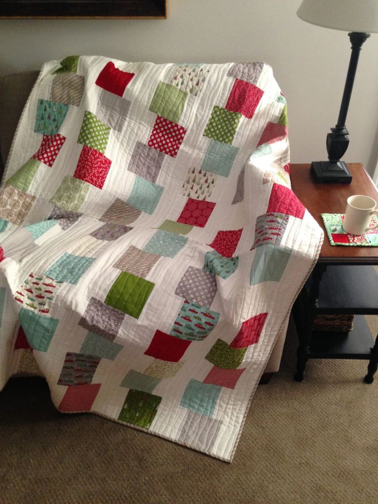 a living room with a couch and a quilted blanket on top of the sofa