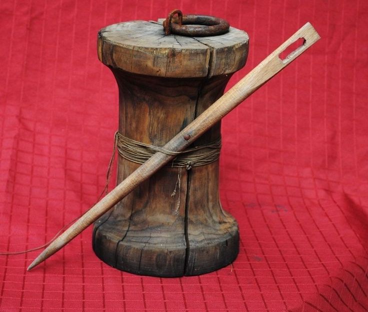 there is a wooden object with a long handle and a stick in it on a red cloth