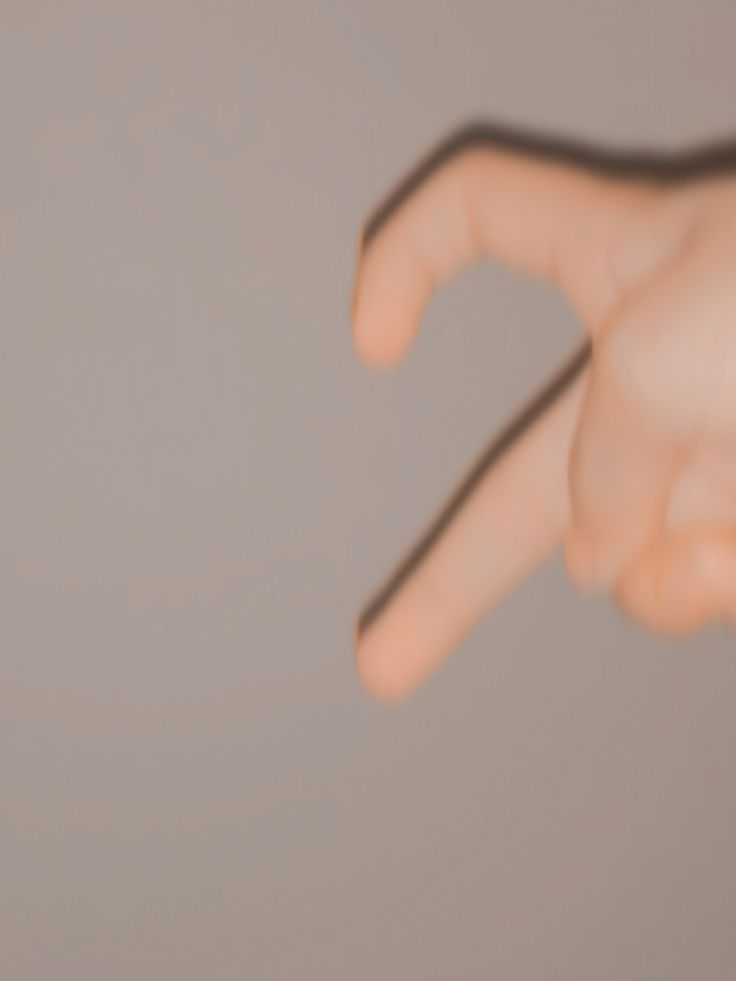 a hand is pointing at something in the air with it's thumb extended up