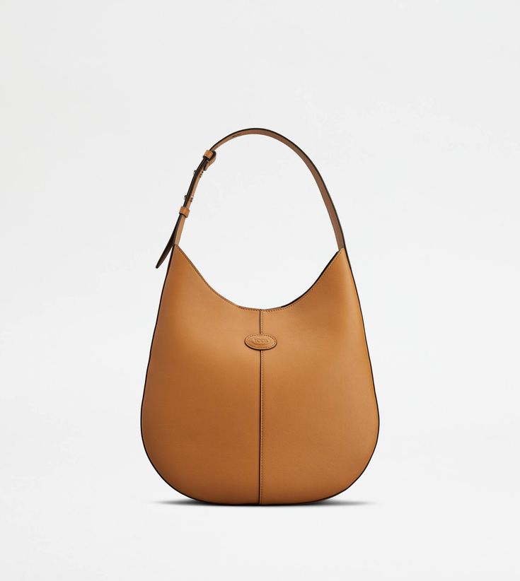 The timeless elegance of the Di Bag style is declined in a hobo version with sober and essential lines. Crafted in fine natural grain calfskin leather, it comes with an adjustable shoulder handle and the characteristic Tod's logo stamped on the front. Complemented by a removable internal pouch, it accompanies your everyday outfits with class and femininity. Gift Boutique, Bag Style, Logo Stamp, Trainers Women, Bago, Hobo Bag, Small Bags, Body Bag, Everyday Look