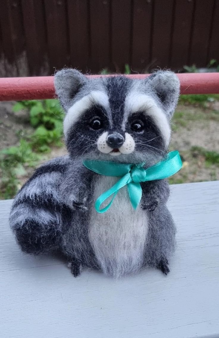 a stuffed raccoon sitting on top of a table