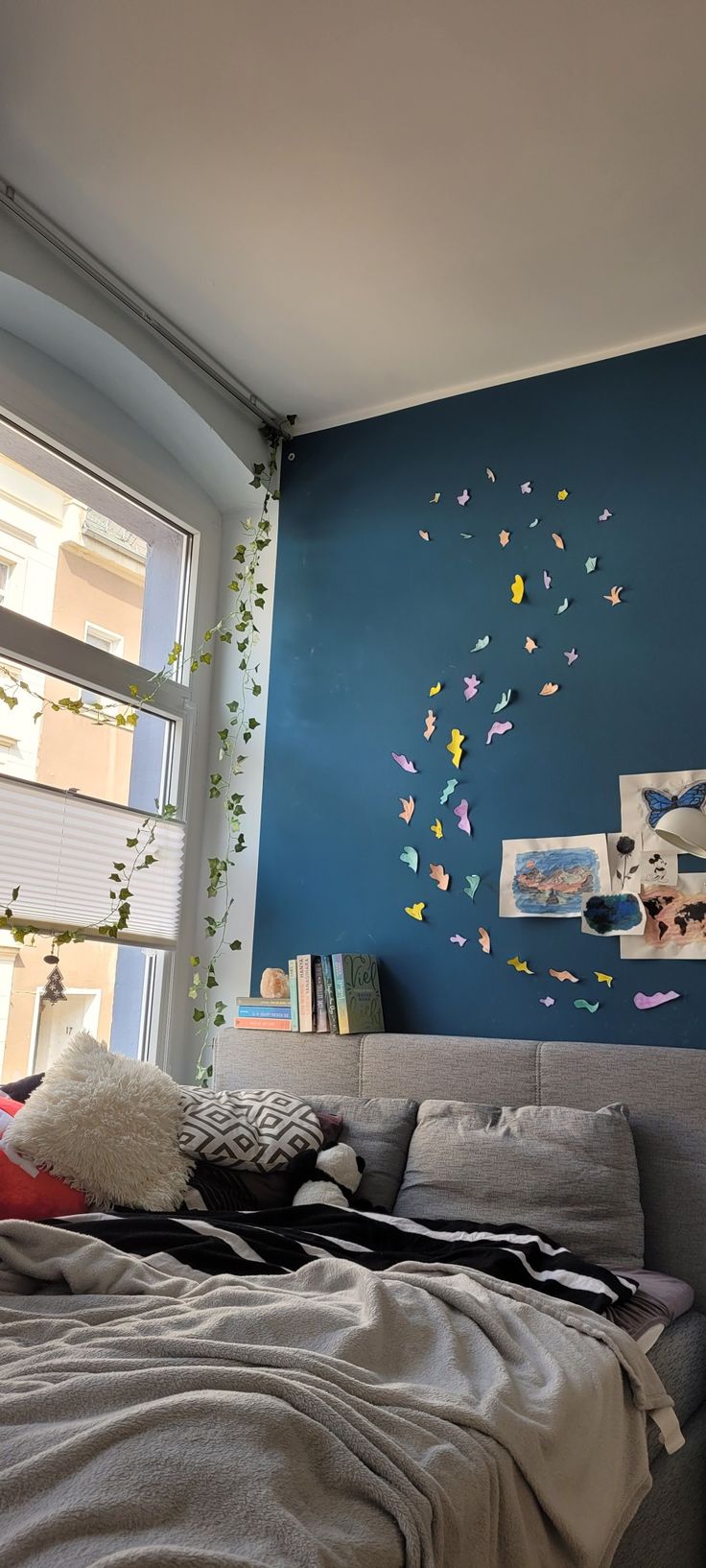 a bedroom with blue walls and butterflies on the wall