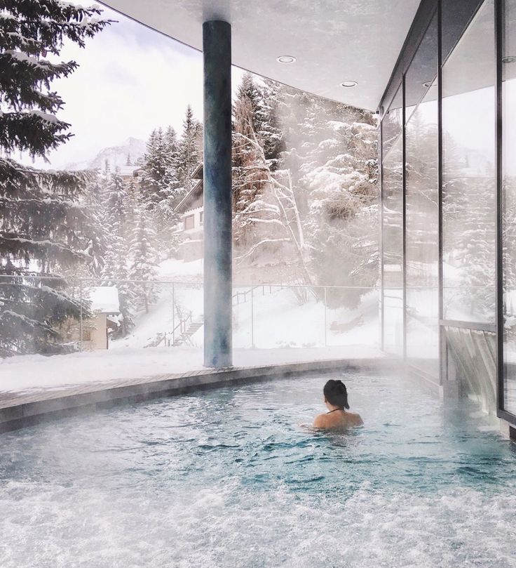 a woman in a hot tub surrounded by snow