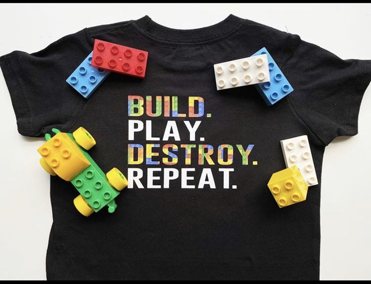 a black shirt with legos on it that says build, play, destroy repeat