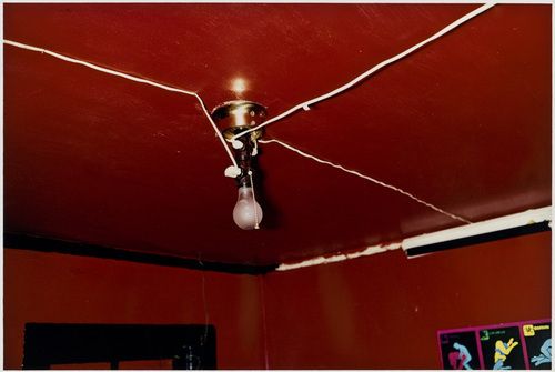 a red room with a ceiling light and some pictures on the wall