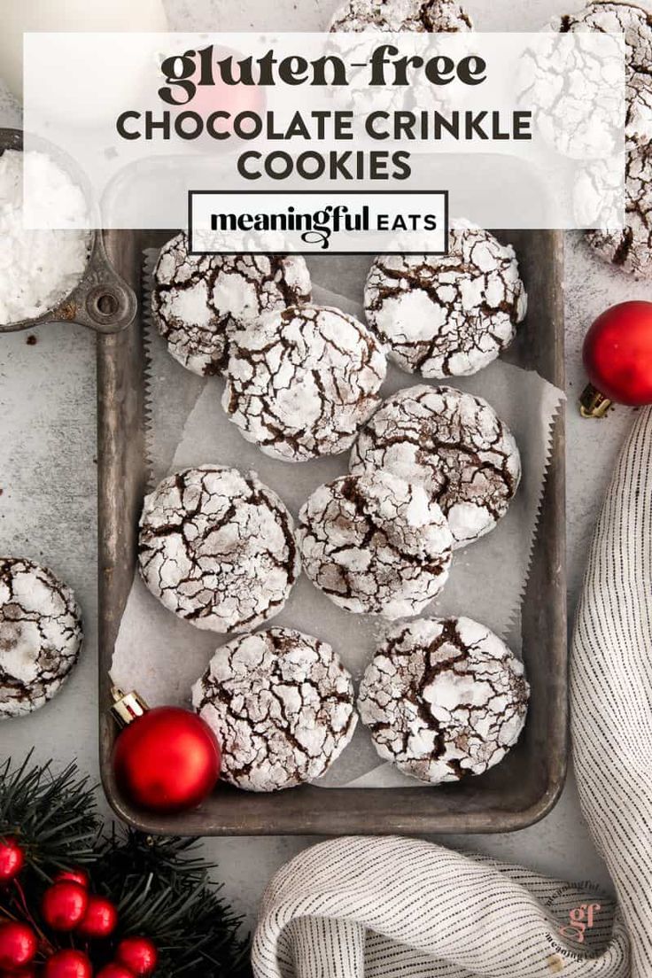 gluten free chocolate crinkle cookies on a baking tray with christmas decorations