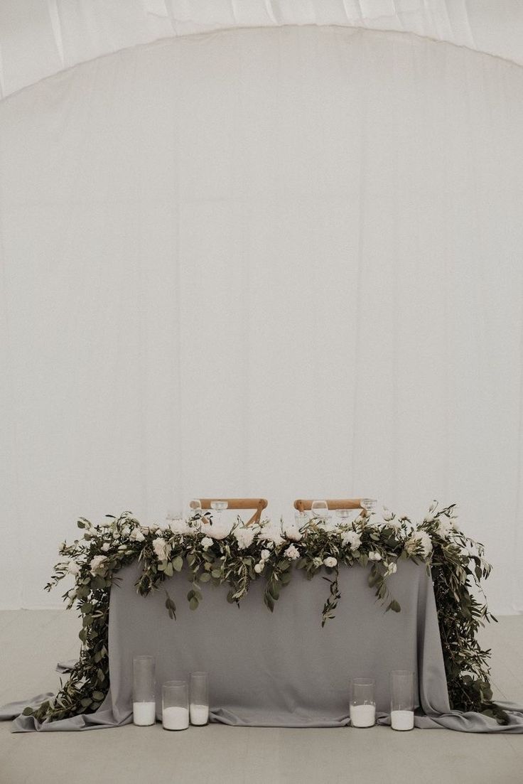 the table is set up with candles and greenery for an elegant touch to the space