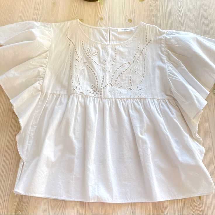 New Without Tags, Never Worn, Bought In Europe 100% Cotton Size 34 Eur, Fits Size 2-4 Us Beautiful Details On The Front Ruched Sleeves Feminine Tops With Smocked Bodice And Flutter Sleeves, Feminine Top With Smocked Bodice And Flutter Sleeves, Spring Tops With Smocked Back And Flutter Sleeve, Flutter Sleeve Tops With Smocked Back For Spring, Summer Tops With Smocked Back And Short Sleeves, Feminine Top With Smocked Back And Flutter Sleeves, Feminine Blouse With Smocked Bodice And Flutter Sleeves, Relaxed Fit Cotton Blouse With Flutter Sleeves, Casual Lace Top Blouse With Ruffle Sleeves