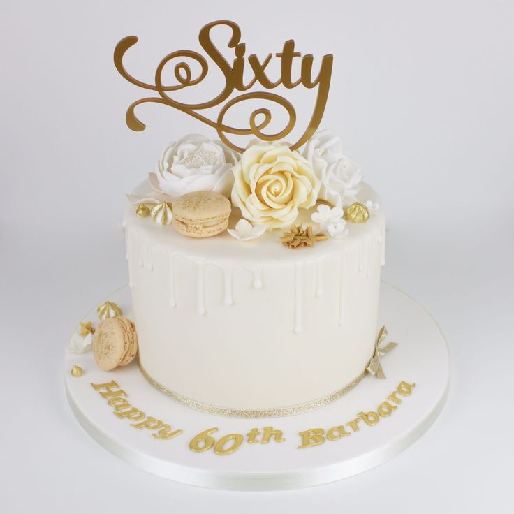 a birthday cake with white frosting and gold decorations on top that says sixtyth birthday