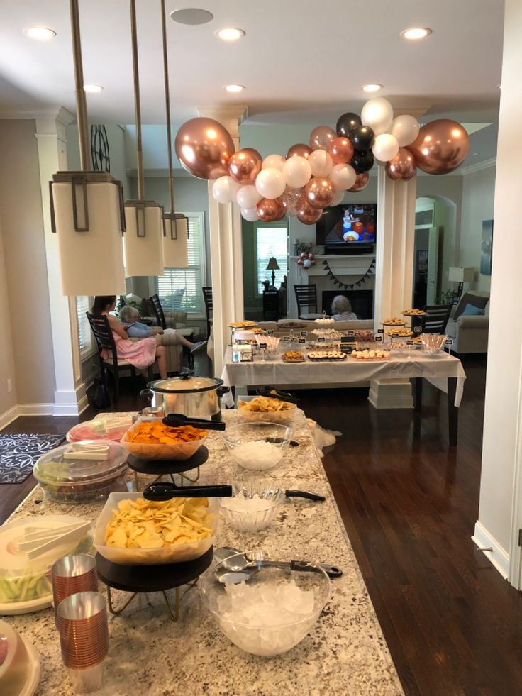 the buffet is set up with food and balloons in the air over it's head