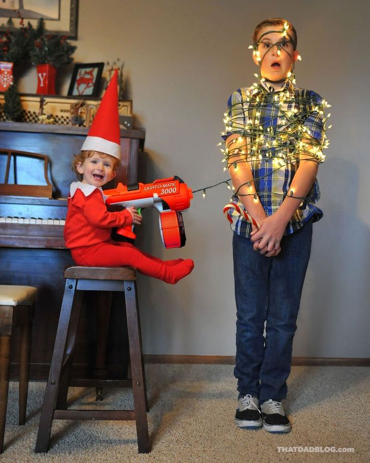 a boy and girl dressed up as elfs playing with an electric driller in their living room