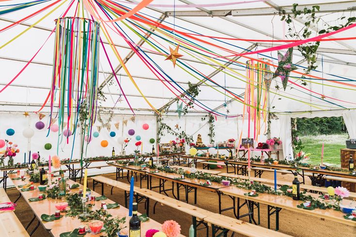 tables and chairs are set up with colorful streamers hanging from the ceiling