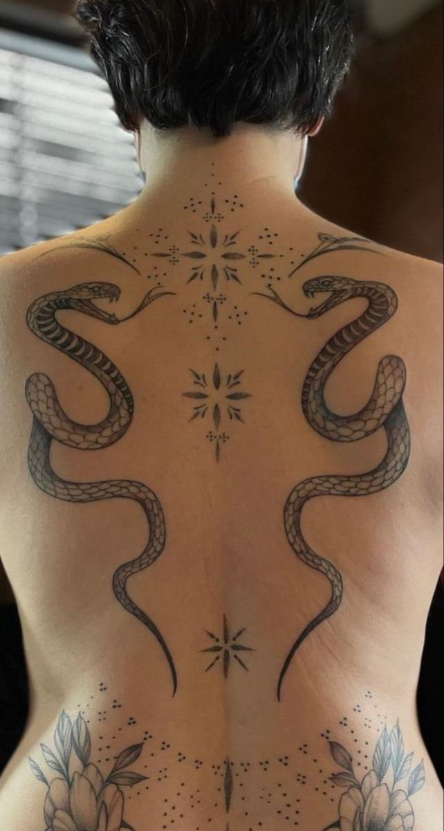 the back of a man with tattoos on his body and an image of a snake